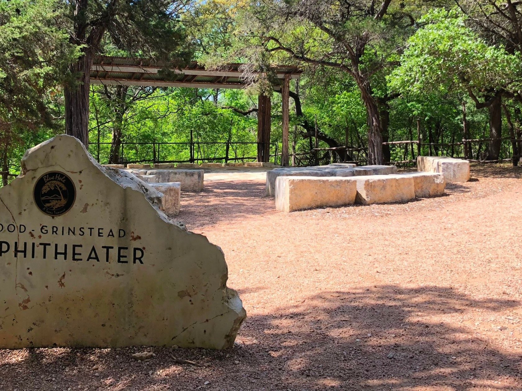 a sign on a dirt ground with trees in the background