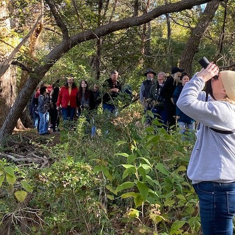 a group of people standing next to a tree