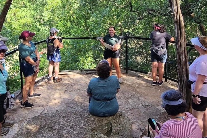 a group of people standing next to a tree