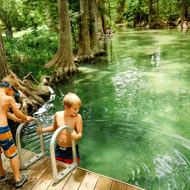 a person sitting on a bench in front of water