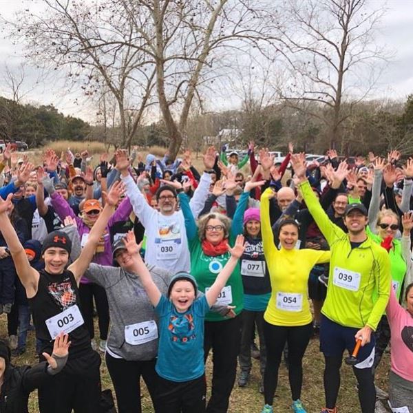 a group of people standing in front of a crowd posing for the camera