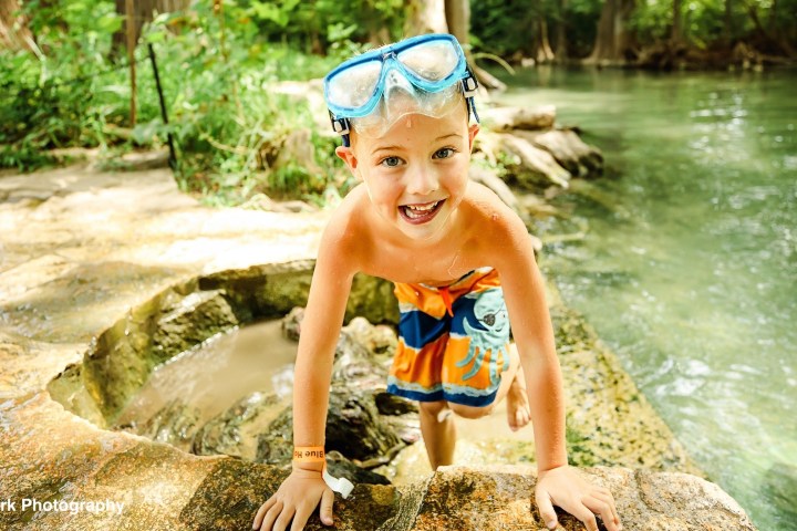 a young boy swimming in a body of water
