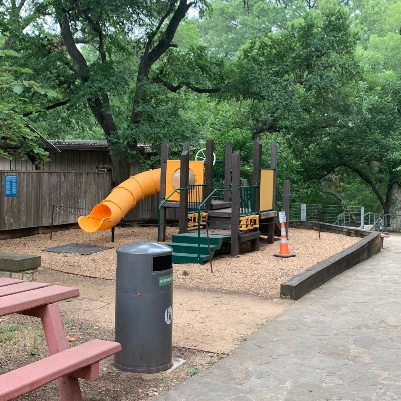 a person sitting on a bench in a park