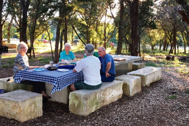 a man sitting on a bench in a park