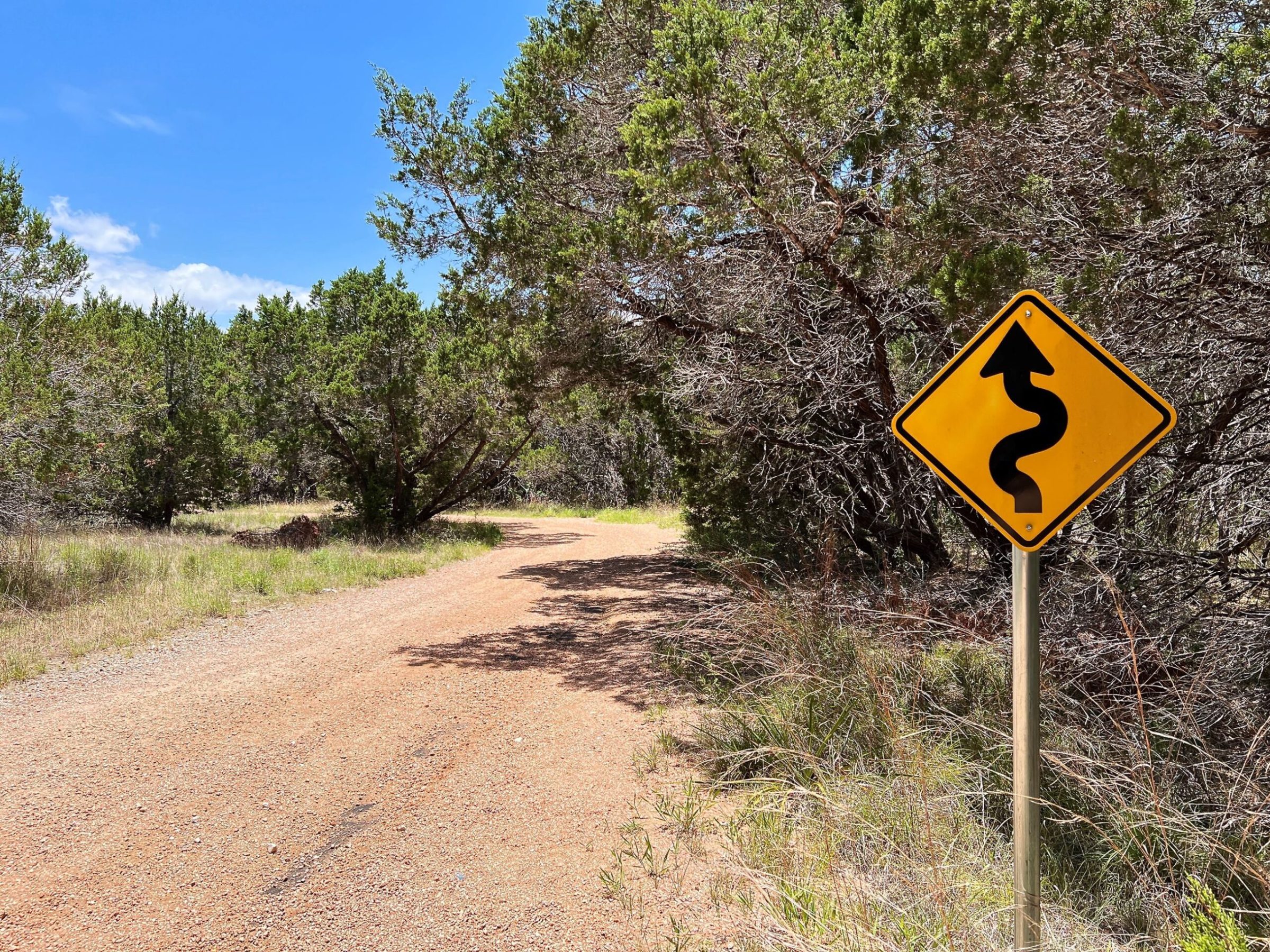 a sign on the side of a dirt road