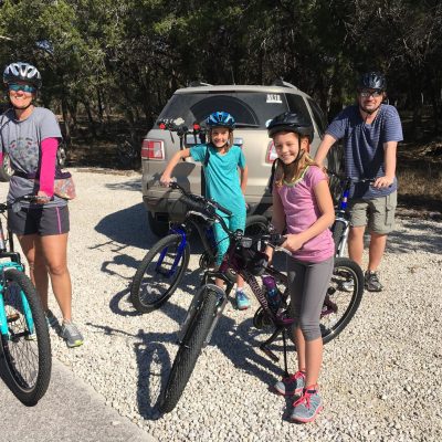 a group of people riding on the back of a bicycle
