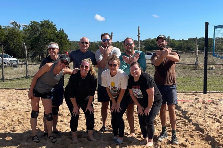 a group of people standing on a beach posing for the camera