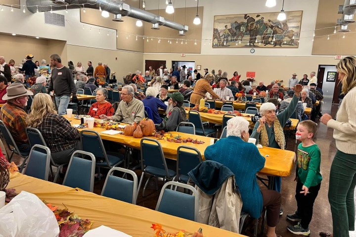a group of people sitting at a table in front of a crowd