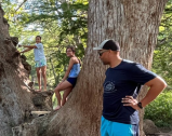 a group of people standing next to a tree